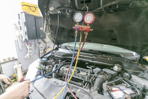 A/C recharge and leak diagnosis on an engine bay with manifold gauges