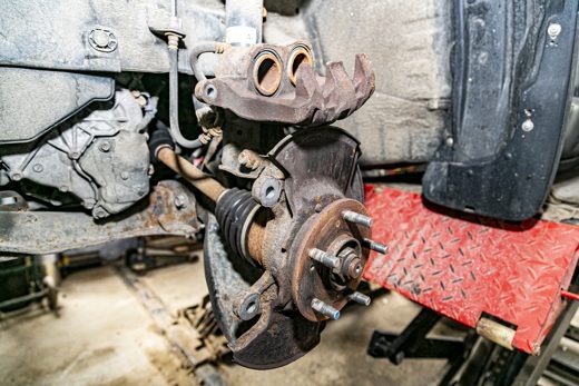 Exposed brake caliper, hub and rotor — checking pads, rotors and suspension