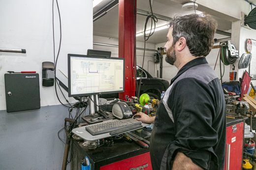 Auto Solve technician reviewing diagnostics on the shop computer for clear, simple answers
