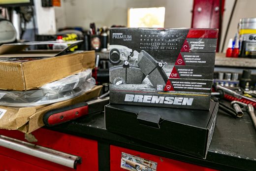 New brake pads and rotors on the workbench — the right parts for the job
