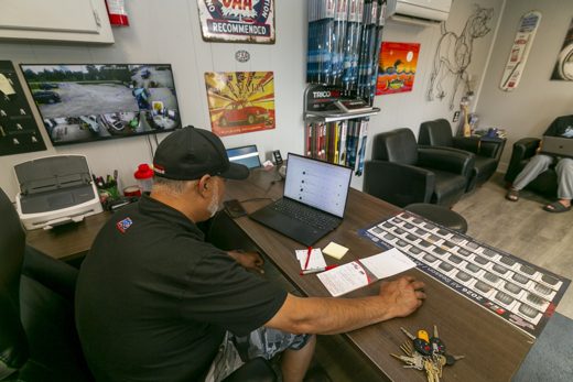 Auto Solve staff handling a vehicle drop-off at the reception desk, keys on the counter