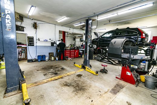 Auto Solve technician looking over a vehicle raised on the lift for a thorough pre-purchase inspection