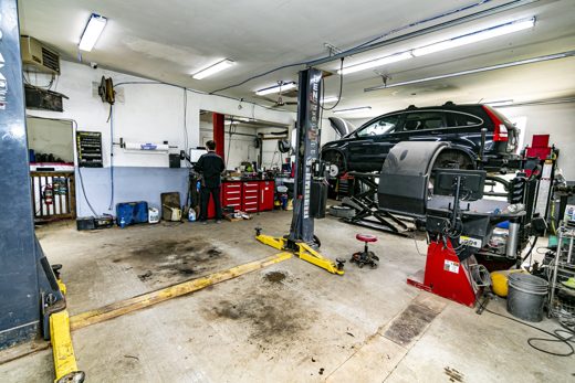 Auto Solve service bay with an SUV on the lift — body and mechanical work handled under one roof