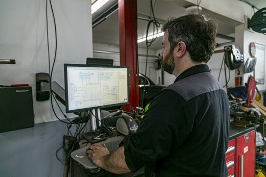Auto Solve technician recalibrating vehicle electronics on the diagnostic computer after a windshield replacement