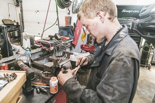 Technician examining a component at the workbench during a digital inspection