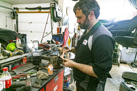 Auto Solve technician inspecting the condition of a vehicle component at the workbench