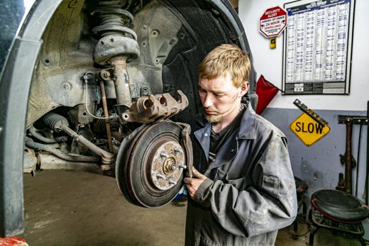 Auto Solve mechanic inspecting a front brake rotor for wear