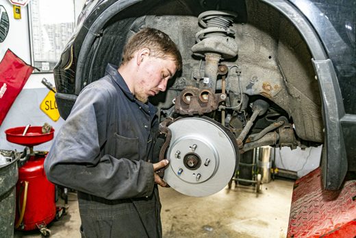 Auto Solve mechanic installing a new brake rotor onto the wheel hub