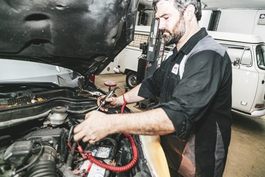 Auto Solve technician testing the car battery and electrical system before a long trip