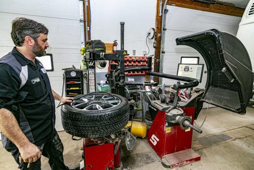 Auto Solve technician spin-balancing a tire and wheel on the balancer