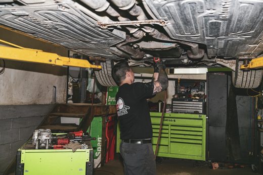 Auto Solve mechanic under a raised vehicle tracking down the source of a noise
