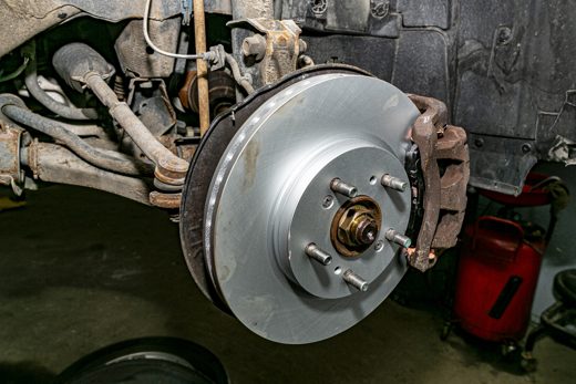 Close-up of a new brake rotor and caliper, the source of squealing and grinding