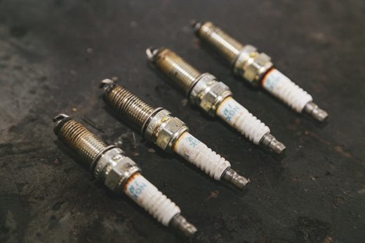Worn spark plugs pulled from a vehicle, documented as inspection evidence